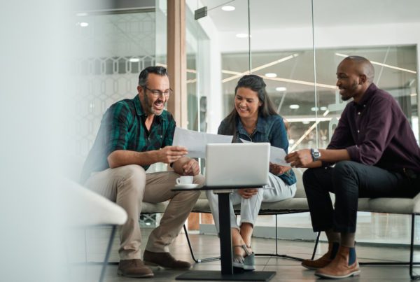 Casual meeting of smiling diverse business team analyzing financial data